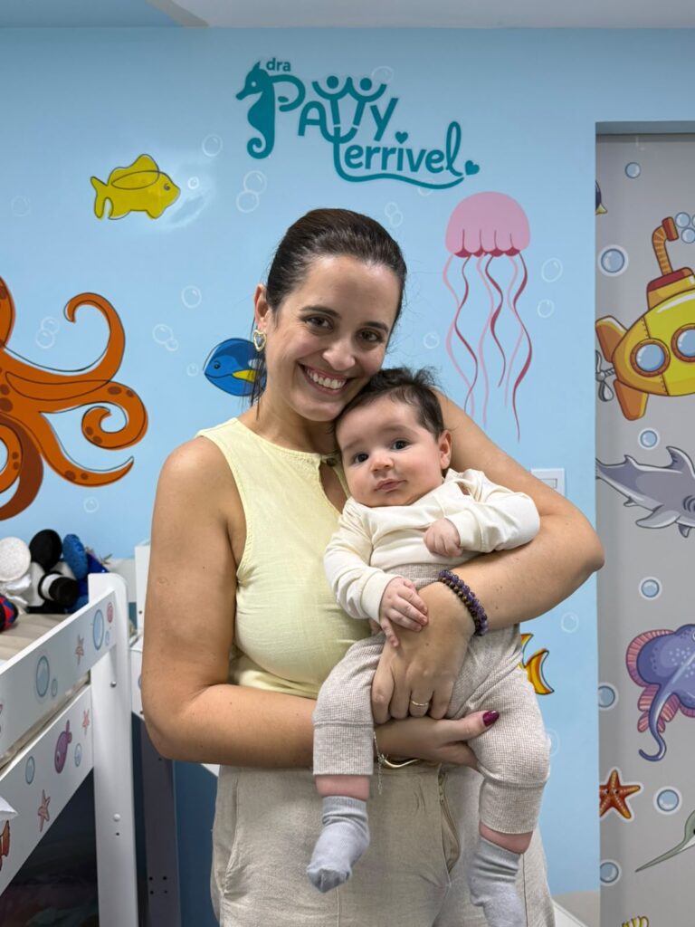 Dra. Patty Terrível com bebê no colo na sala decorada com o fundo do mar