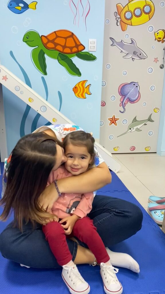 Dra. Patty Terrível abraçando uma paciente no tatame da sala