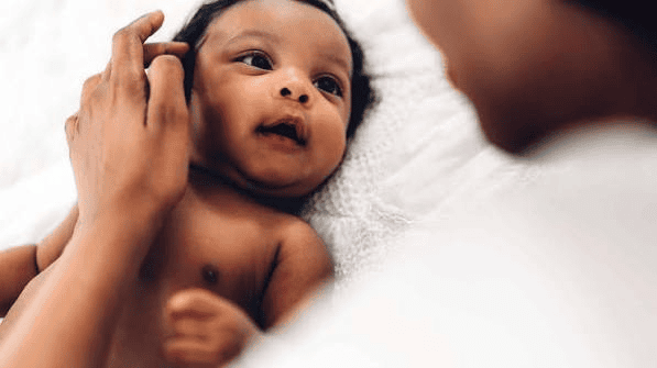 Mãe observando atentamente recém-nascido, verificando sinais de alerta