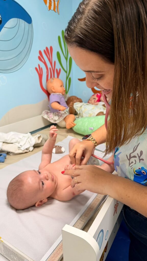 Dra. Patty Terrível examinando um recém-nascido na consulta