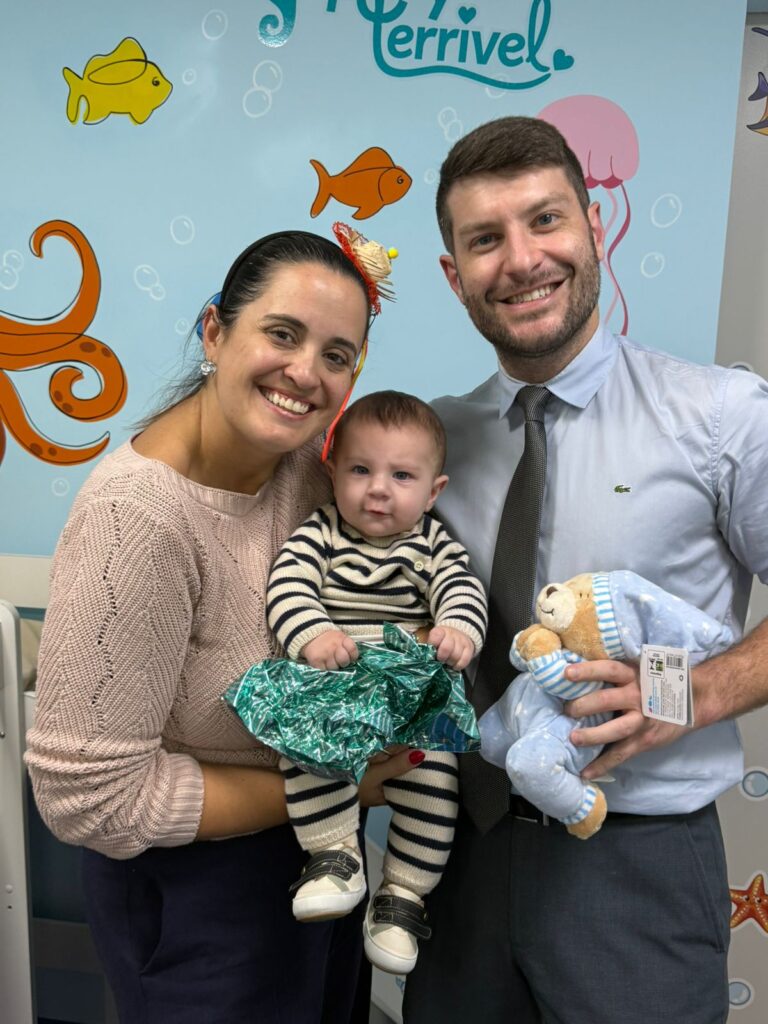 Dra. Patty Terrível com bebê e o pai na consulta, em clima de festa junina
