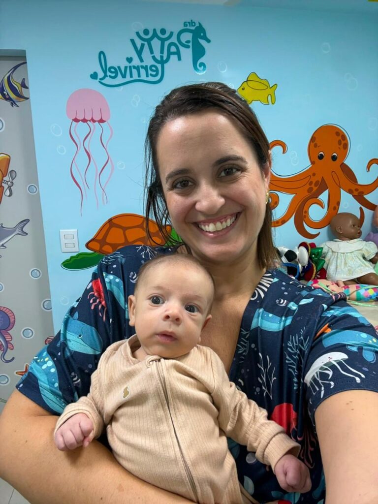 Dra. Patty Terrível com bebê no colo na sala decorada com o fundo do mar