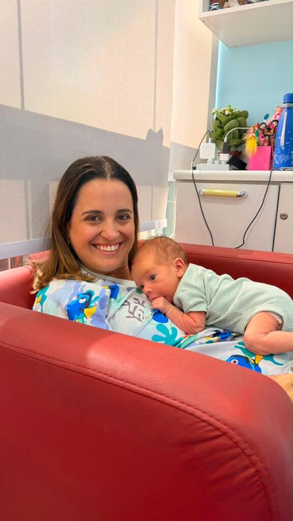 Dra. Patty Terrível sorrindo com recém-nascido no colo