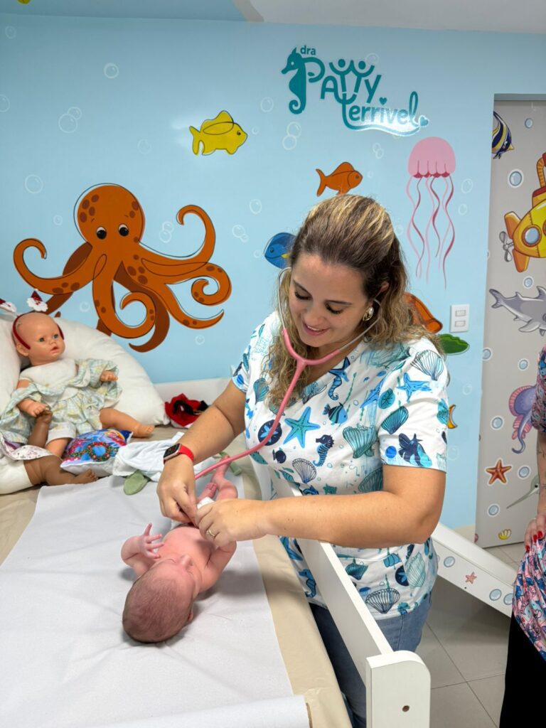 Dra. Patty Terrível auscultando um recém-nascido na primeira consulta